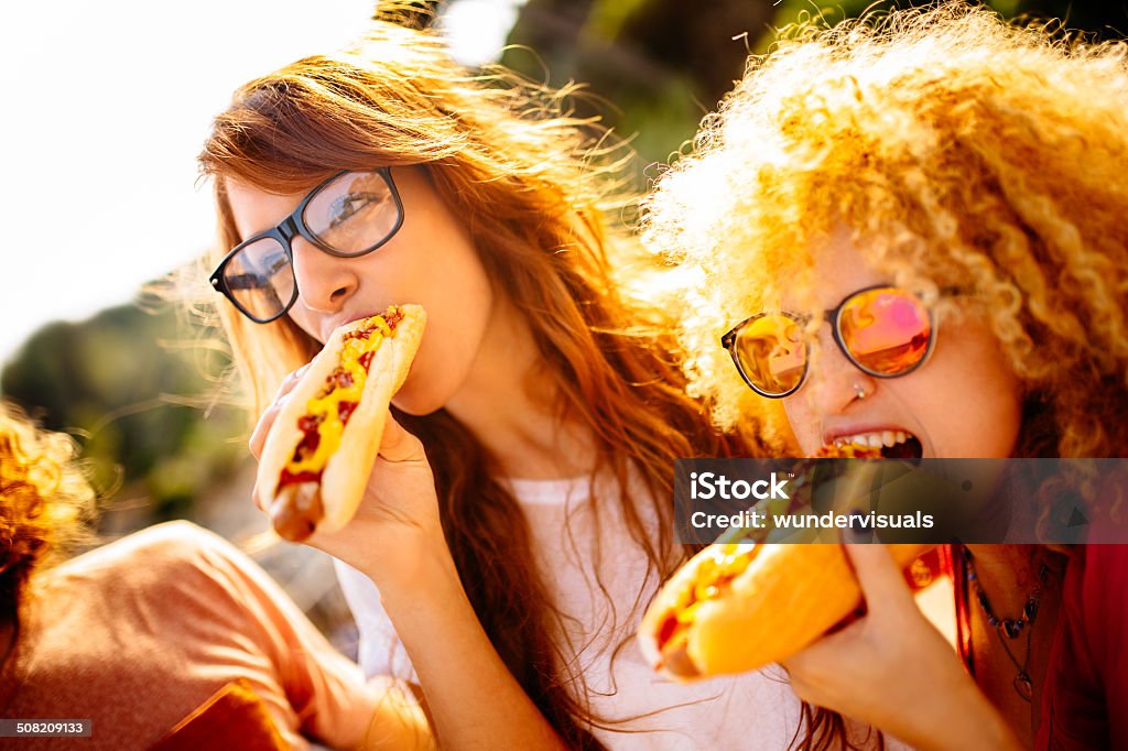 Girls having fun eating hotdogs