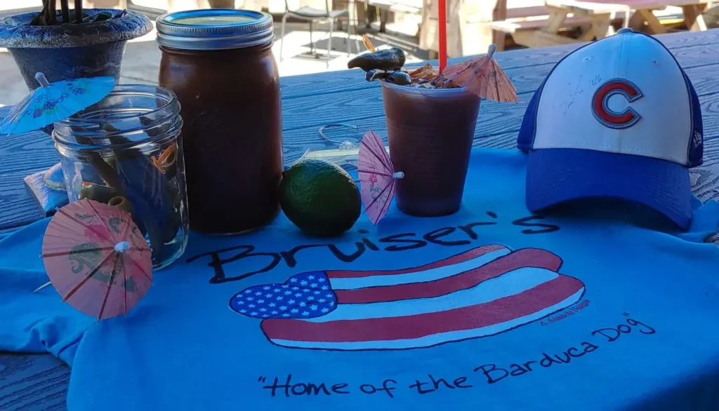 Cubs Bloody Mary setup with a Cubs cap on the bar